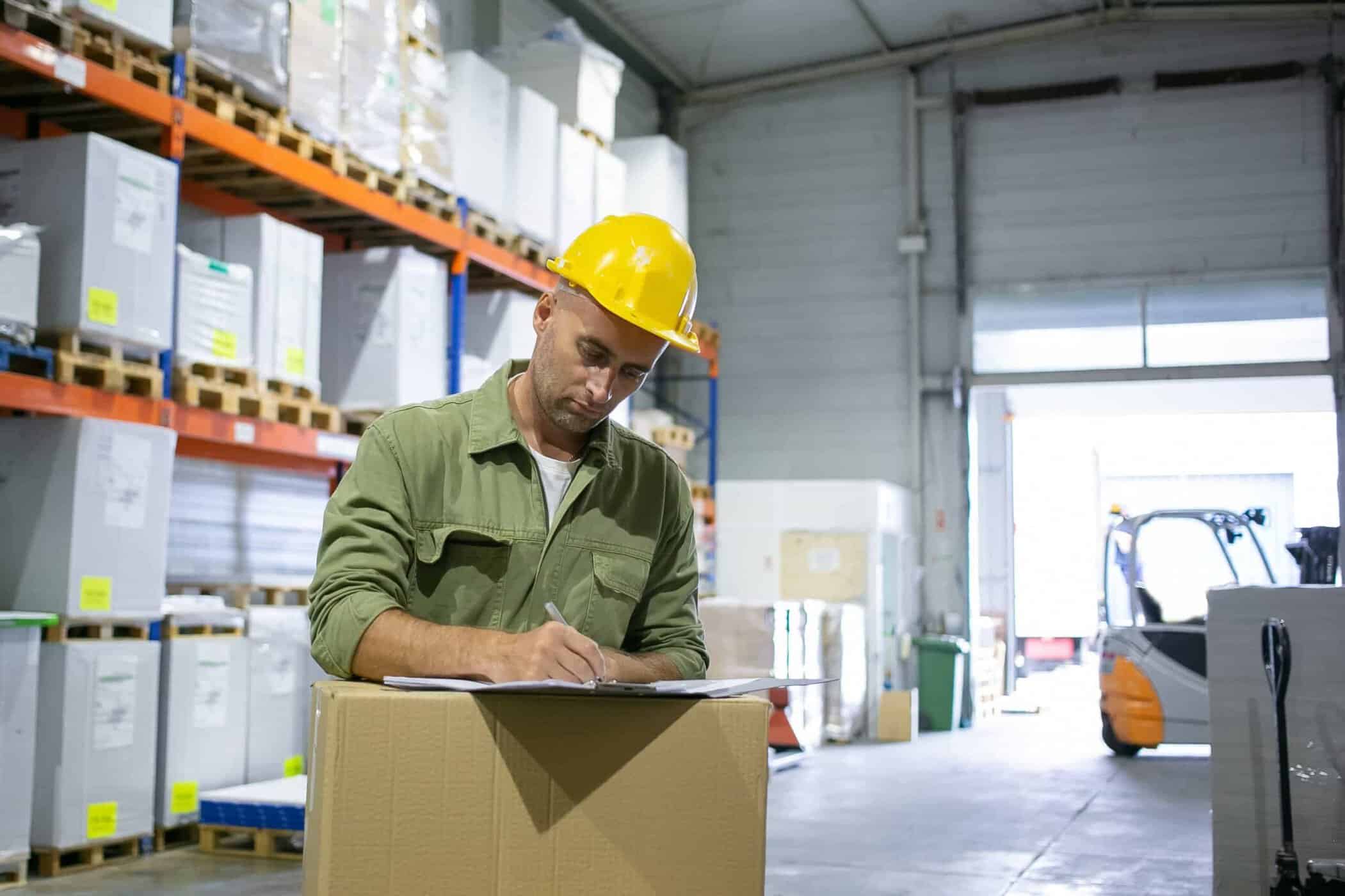 Lavoratore in magazzino che compila documenti